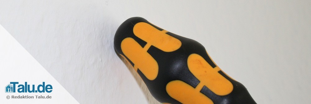 Wand mit einem Schraubendreher abklopfen