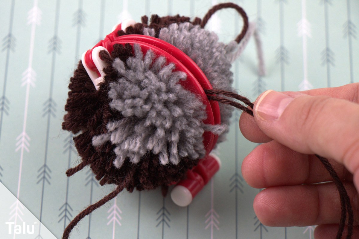 Pompom mit Faden fixieren