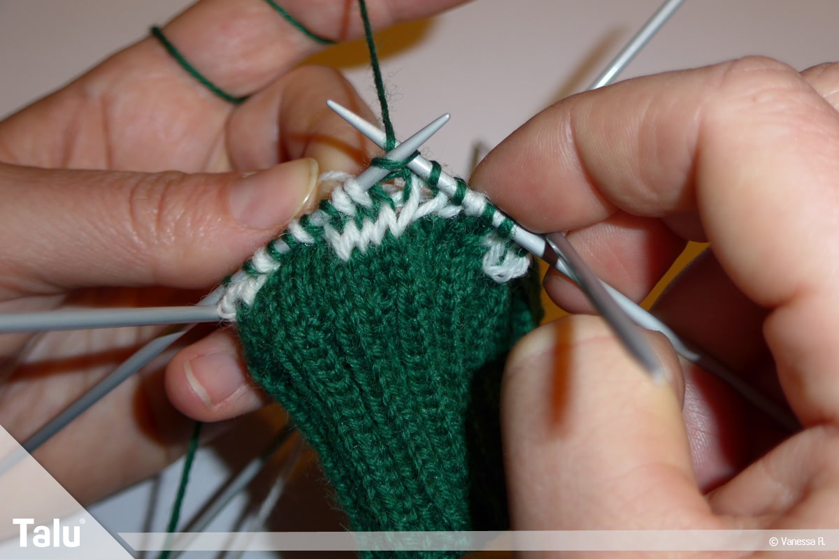 Gestrickte Socken, Norwegermuster, Nadelspiel mit Strickarbeit