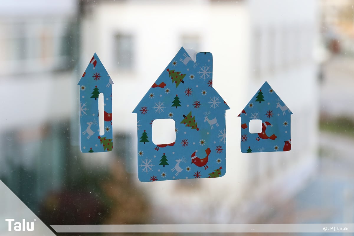 Basteln mit Papier an Weihnachten, Ideen, Fensterdeko aus Häusern an Glasscheibe anbringen